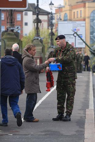 Remembrance parade at the Cenotaph Clarence Place, Newport - soldier Chris Forte sells poppies