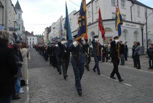 Standard bearers march towards the Cenotaph at Chepstow on Sunday