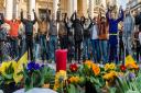 DEFIANCE: People hold hands in solidarity near a memorial to attack victims outside the stock exchange in Brussels. At least 31 people were killed in terror attacks in the city on Tuesday