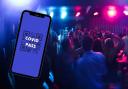 Composite image showing people dancing in a nightclub and a mock-up Covid Pass on a smartphone. In Wales the Senedd has been debating the pros and cons of a vaccine pass. Original picture (background): Pexels