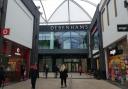 Shoppers walk past the former Debenhams store in the Friars Walk shopping centre, Newport.