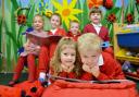 Tommy Burke, (front right) a Year 1 pupil helping nursery pupil Alys-Marie Hawkins-Price (left) with her reading in the nursery reading group