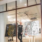 Nathan Wyburn among some of his art on exhibition in the Morgan Quarter Arcade, Csardiff. Picture: Christian Stones