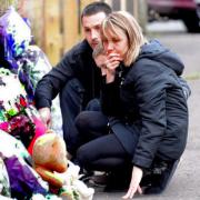 DEVASTATION: Nikitta Grender's mother Marcia, father Paul and younger brother Luke with the floral tributes at the scene