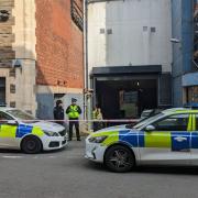 Police officers are standing guard and have cordoned off an alleyway near Upper Dock Street in Newport city centre.