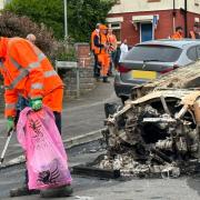 Council workers cleaning up debris in Ely following a night of disorder.