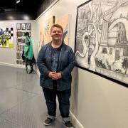 Kristian Ofsteng next to his piece about Newport at the Coleg Gwent: Art & Design students exhibition at the Riverfront Theatre.