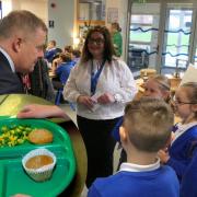 Jeremy Miles talking with pupils at Dewstow Primary in Caldicot where he ate a school dinner with them earlier this year.