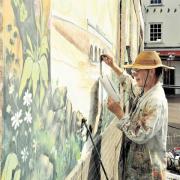 COLOURFUL: Dave Parkinson working on the Jubilee Mural