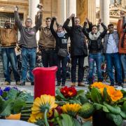 DEFIANCE: People hold hands in solidarity near a memorial to attack victims outside the stock exchange in Brussels. At least 31 people were killed in terror attacks in the city on Tuesday