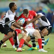 TOUGH GOING: Britain's Mark Bennett feels the force of Fiji during the gold medal match