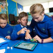 (L-R) Isaac Willmore, Callum David Williams and Callie Jones coding with Lego to make a robot
