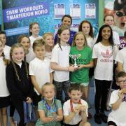 WINNERS: Liz Johnson presents the trophy to Charles Williams' second team of swimmers