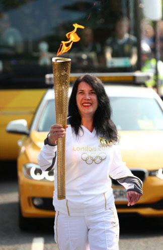 Torchbearer 015 Louise Brown carries the Olympic Flame on the Torch Relay leg between Malvern and Malvern Wells