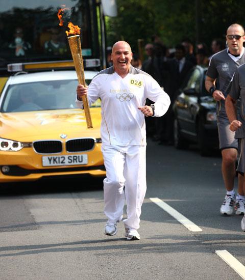 Torchbearer 026 Richard Evans carries the Olympic Flame on the Torch Relay leg between Malvern and Malvern Wells