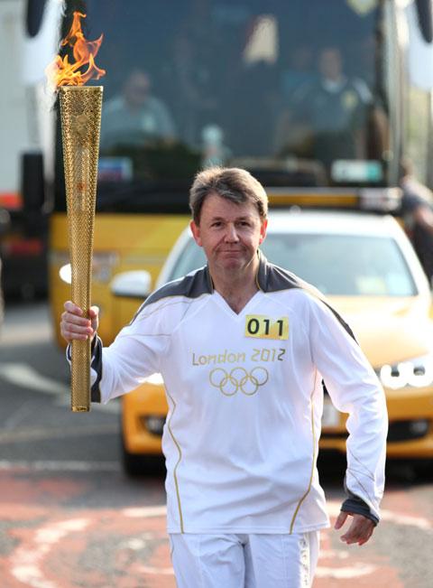 Torchbearer 011 Mark Williamson carries the Olympic Flame on the Torch Relay leg between Worcester and Powick. 