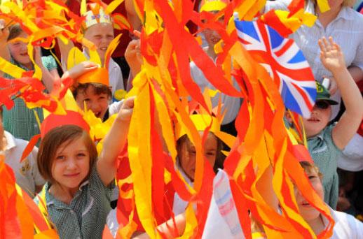Local schoolchildren wait for the Olympic Torch Relay to arrive in Monmouth.