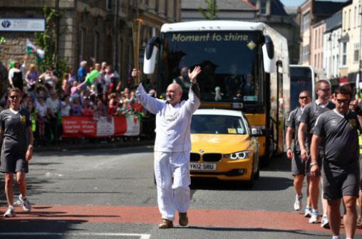 Torchbearer 070 Eric Whitlock carries the Olympic Flame on the Torch Relay leg between Blaenavon and Pontypool.
