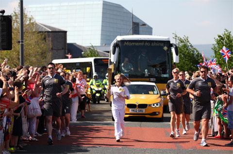 Torchbearer 073 Caitlin Exton carries the Olympic Flame on the Torch Relay leg through Newport. 