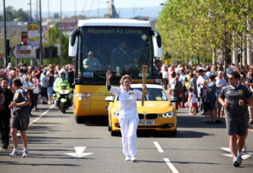 Torchbearer 074 Sarah Baker carries the Olympic Flame on the Torch Relay leg through Newport.