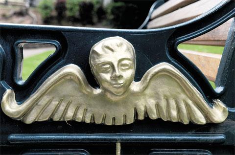 FACE OF AN ANGEL: The end of a bench in Beechwood Park, Newport CT_4578