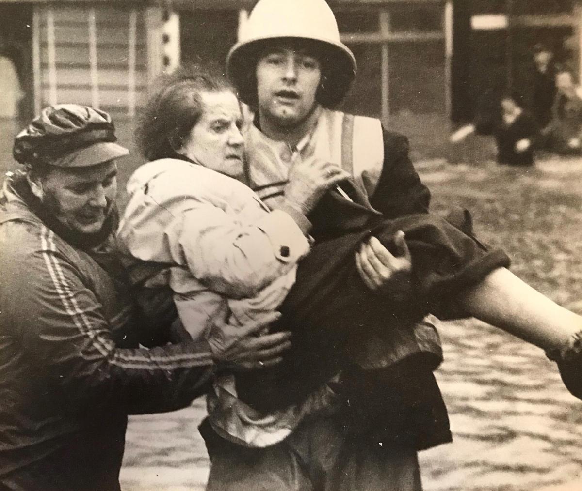 A fireman carries a pensioner to safety in Risca after heavy rain caused floods in 1979
