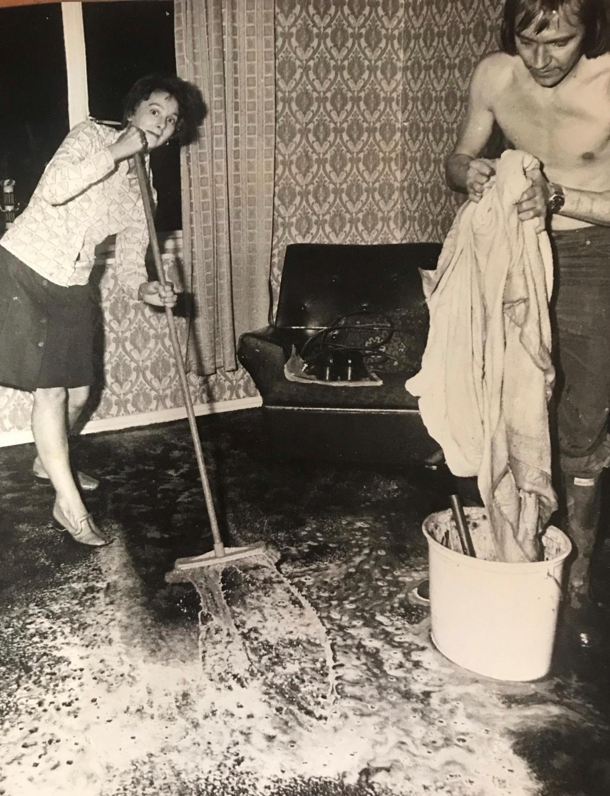 Mr and Mrs David Nichols mop up after flooding in Gaer Vale in 1976