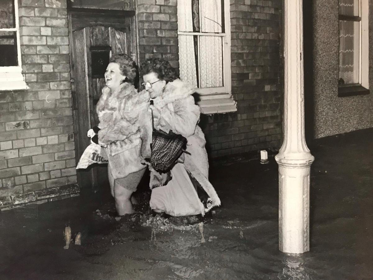 Two women wade through flood water in Argyle Street, Newport, in 1981