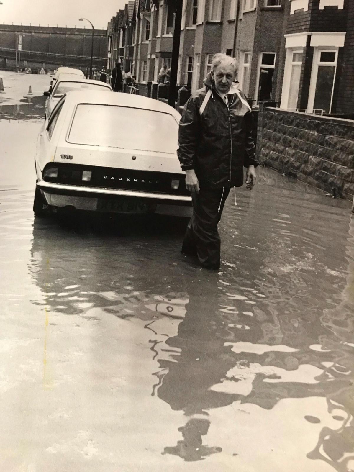 Mr Kenneth Heanes, of Malpas Road, wades through flood water outside his home in 1983