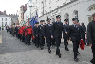 Firefighters march towards the cenotaph at Chepstow on Sunday
