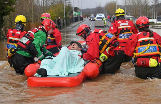 Mountain Rescue team members rescue Peter Morgan from his house where he has lived his whole life, which has been flooded in Monmouth, in the aftermath of Storm Dennis. Picture: Ben Birchall/PA Wire