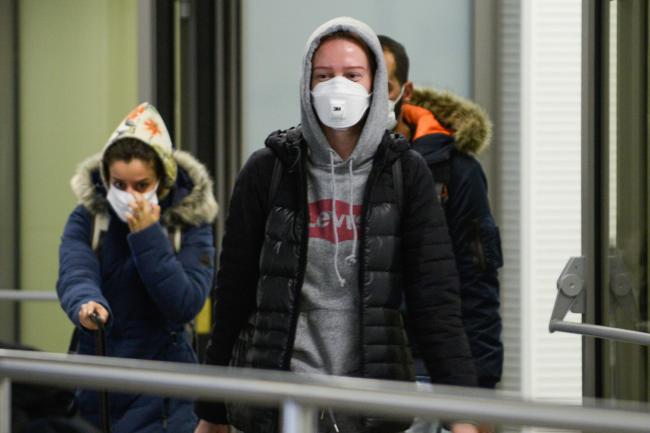 Passengers wear face masks after landing at Krakow International Airport on February 26, 2020 in Krakow, Poland. Photo by Omar Marques/Getty Images