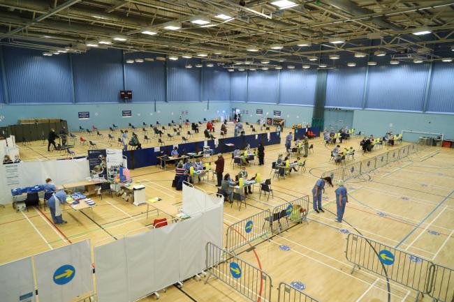 Members of the public receive a dose of the Oxford/AstraZeneca vaccine at a vaccination centre at Cwmbran Stadium, February 2021. Picture: PA Wire