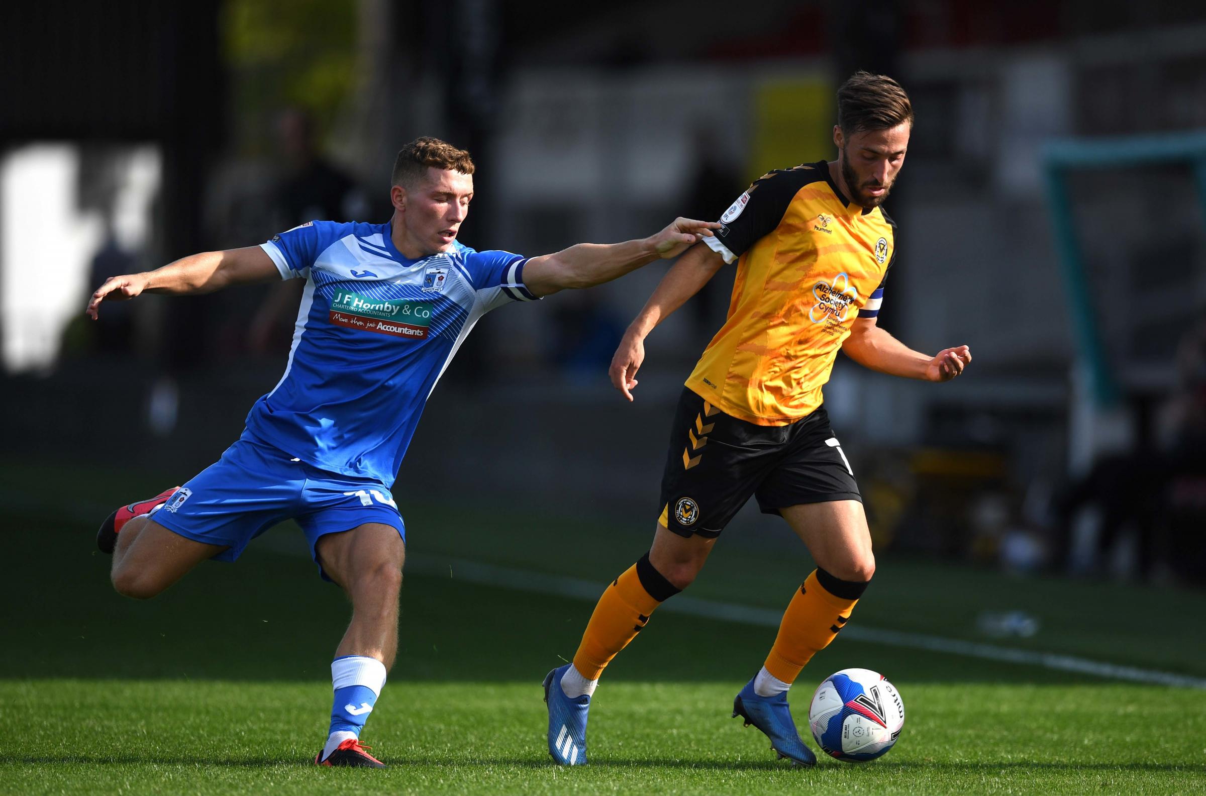Robbie Willmott of Newport County is tackled by Lewis Hardcastle of Barrow.