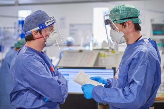 South Wales Argus: Two doctors handover patients at the start of a new shift. PPE made even the simplest of tasks onerous and difficult. South Wales Argus: Two doctors handover patients at the start of a new shift. PPE made even the simplest of tasks onerous and difficult.