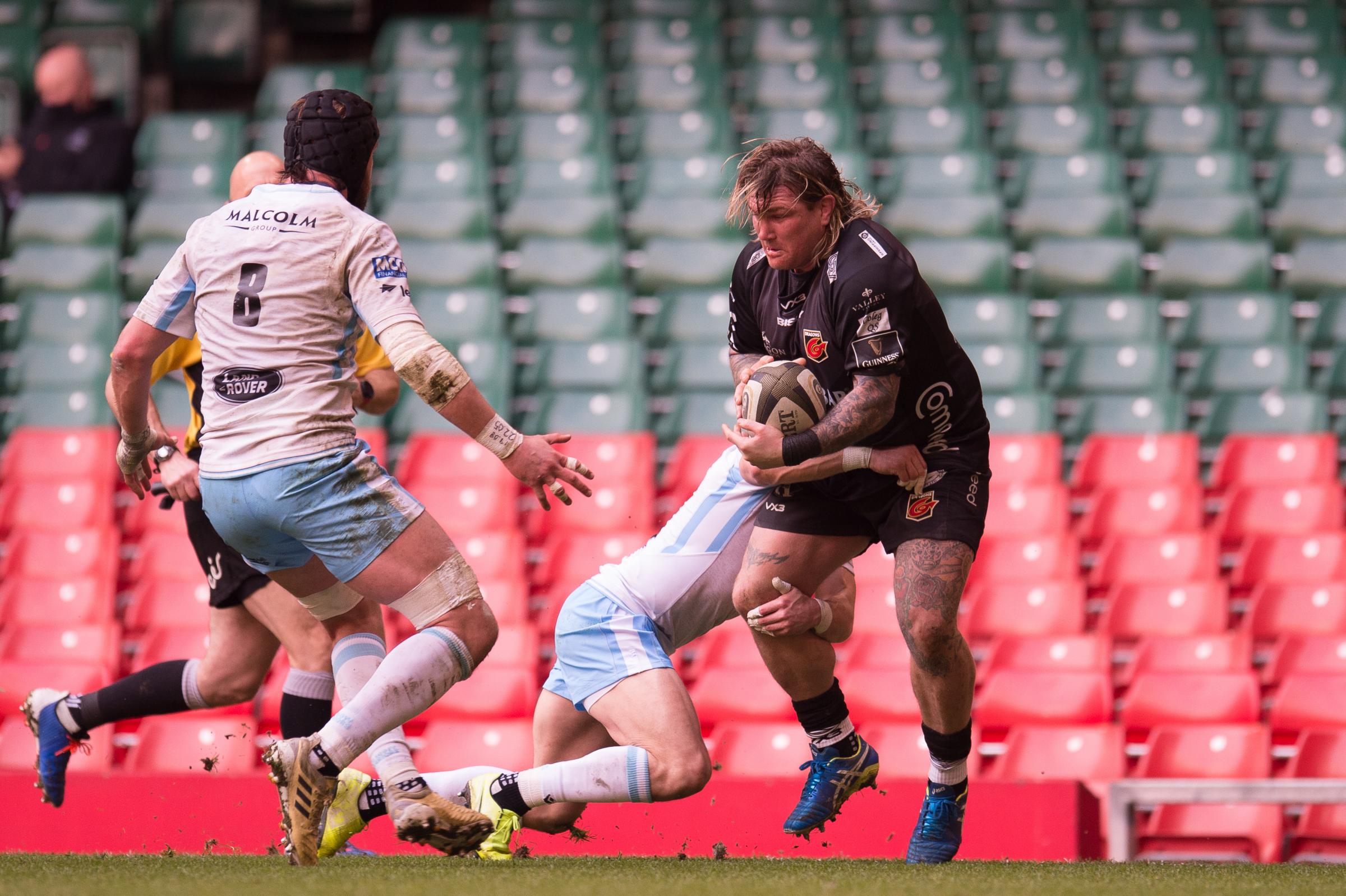 Richard Hibbard of Dragons is tackled by Sean Kennedy of Glasgow Warriors