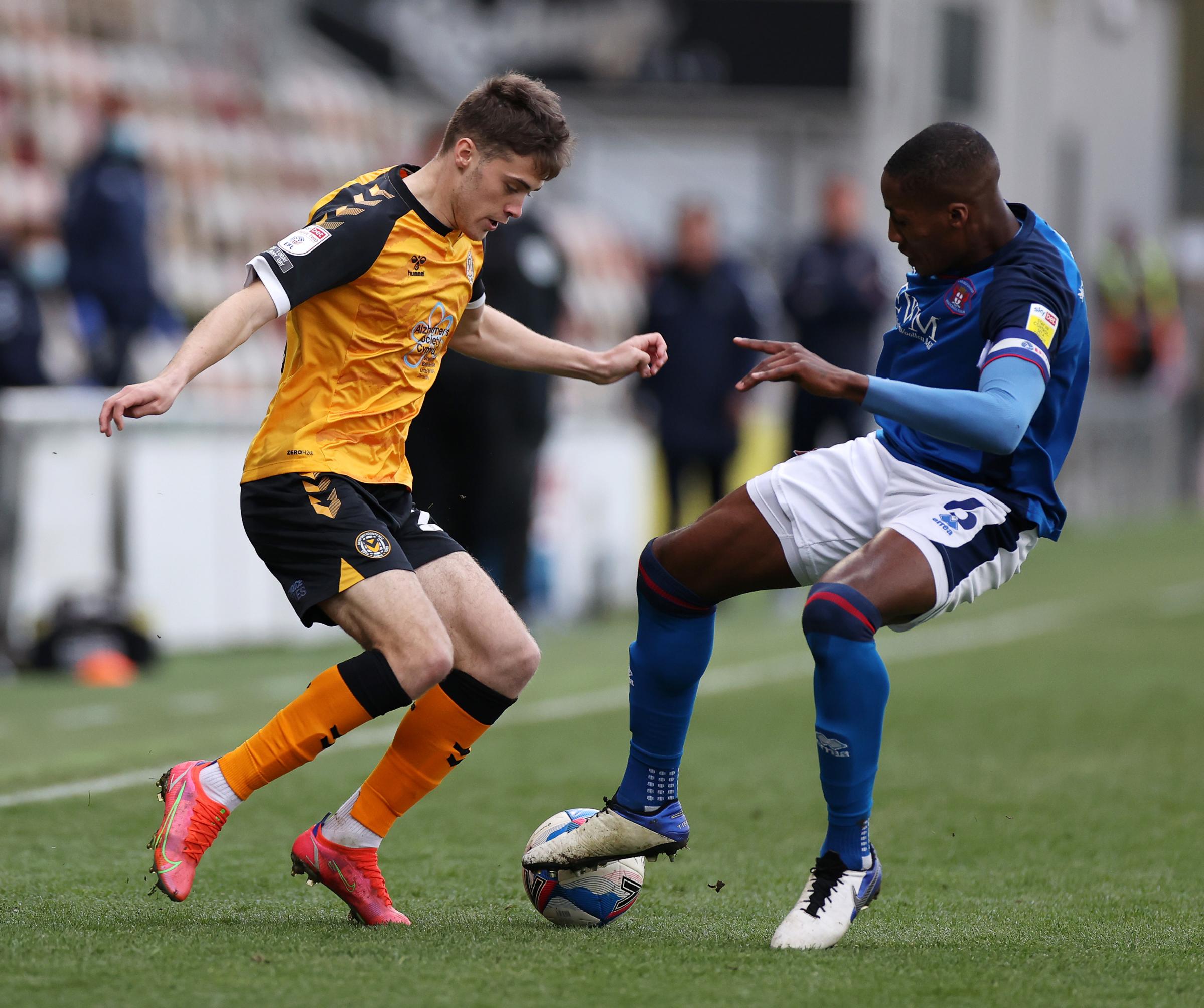 LIVELY: Lewis Collins of Newport County is tackled by Aaron Hayden of Carlisle United.