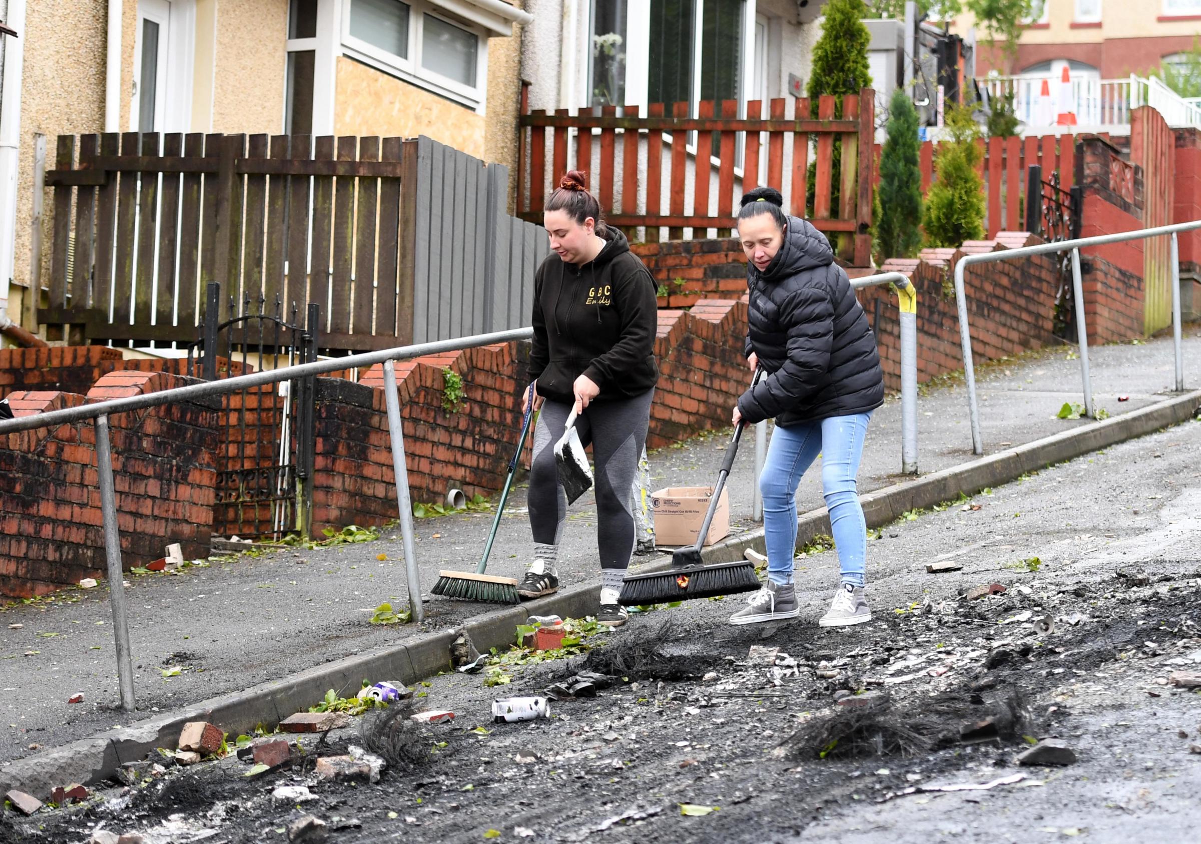 21.05.21 - Local residents and council workers clear up after cars were burnt out and windows smashed during the violence and riots in the Mayhill area of Swansea, South Wales last night. Pictures: Huw Evans Agency