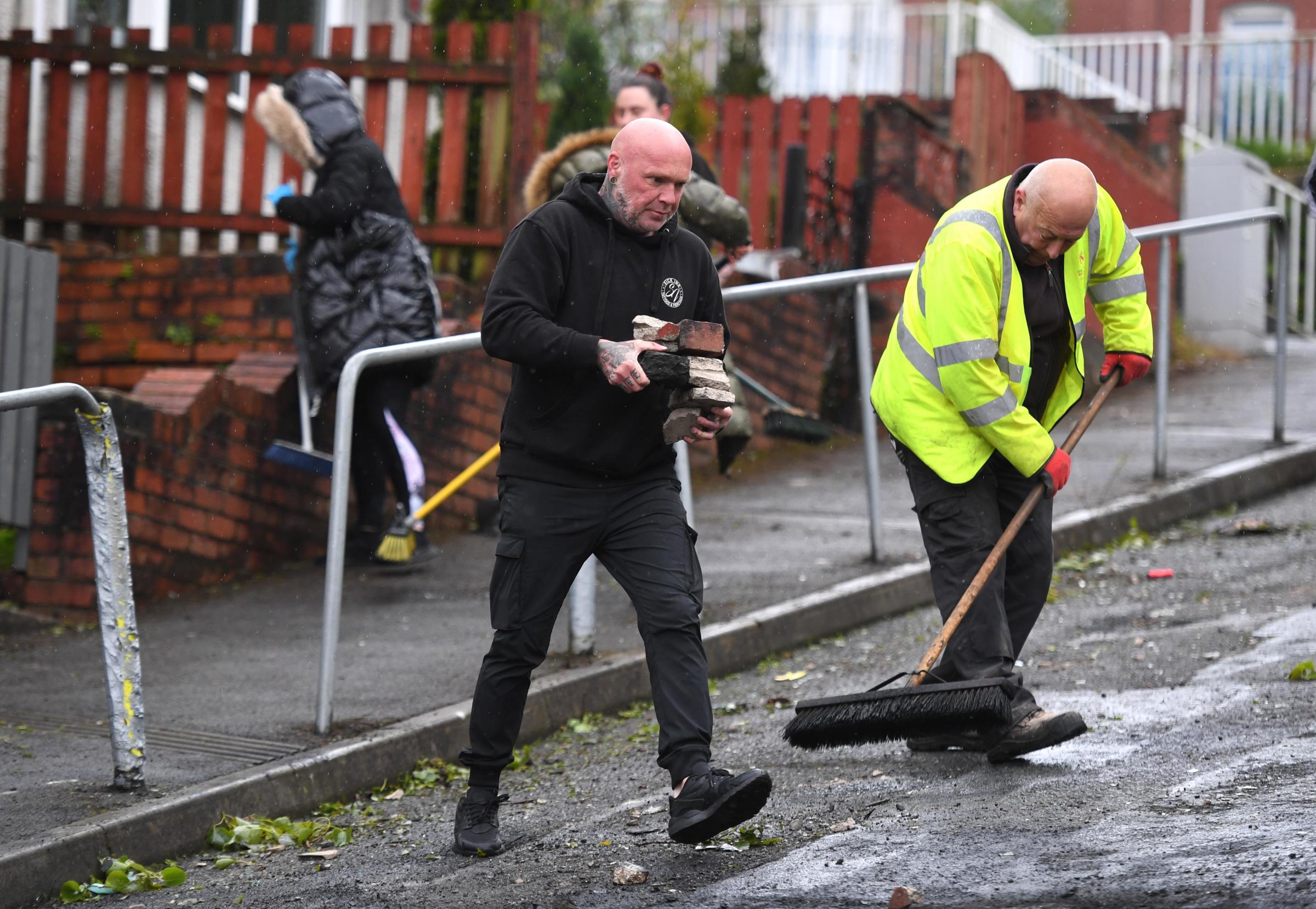21.05.21 - Local residents and council workers clear up after cars were burnt out and windows smashed during the violence and riots in the Mayhill area of Swansea, South Wales last night. Pictures: Huw Evans Agency