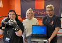 L-R: Amy Shea and Kelsie Cantelo from NCH present a laptop to Shereen Williams of KB Boxing