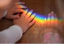 Children with hands on a rainbow