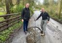David Davies MP (L)  and Cwmyoy resident Rob Abell inspect the potholes on Cwm Road