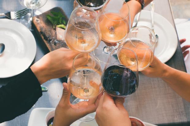 South Wales Argus: A group of people toasting with wine glasses. Credit: Canva