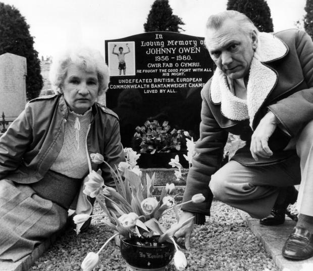 South Wales Argus: Parents Dick and Edith at Johnny's grave in Merthyr the Welsh inscription describes him as 'a true son of Wales' and in English states 'He fought the good fight with all his might' and lists his boxing titles Picture: Huw Evans Agency
