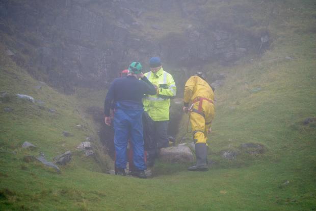 South Wales Argus: Rescuers at the entrance of the Ogof Ffynnon Ddu cave system near Penwyllt, Powys in the Brecon Beacons, Wales, as rescue mission is underway to save a man who has been trapped inside a cave, after falling on Saturday. (PA)