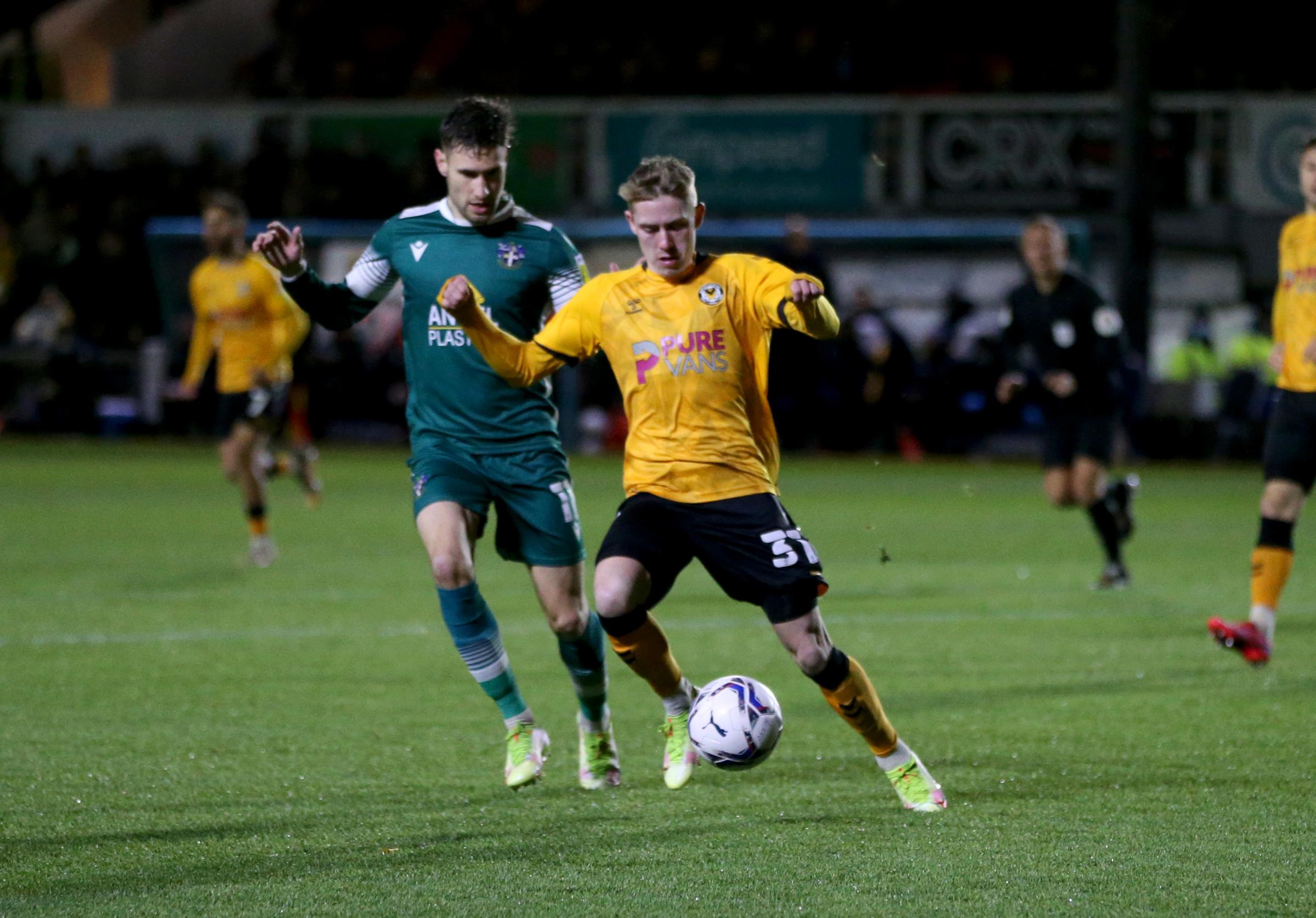 Ollie Cooper of Newport County gets away from Will Randall of Sutton United