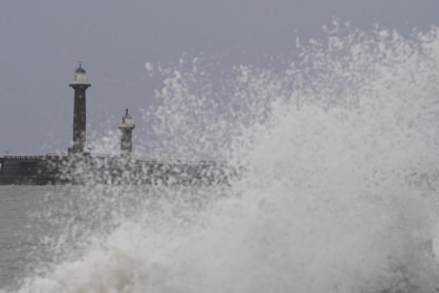 South Wales Argus: Big waves against the sea wall in Whitby, Yorkshire. Photo via PA/Danny Lawson.