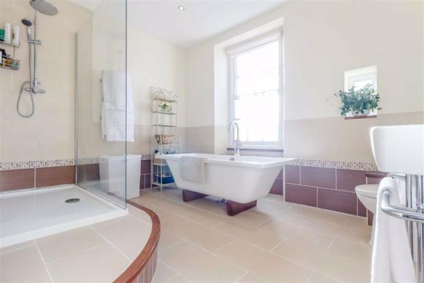 South Wales Argus: A bathroom inside the property - with a freestanding bath (Credit: Archer & Co)