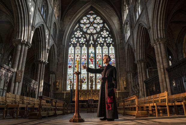 South Wales Argus: Very Reverend John Dobson Dean of Ripon lights a candle to mark the second anniversary of the first national coronavirus lockdown at Ripon Cathedral, North Yorkshire, ahead of the National Day of Reflection on Wednesday (PA)