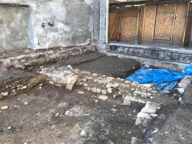 South Wales Argus: A medieval wall. Beneath the blue sheet was where some of the bodies were found